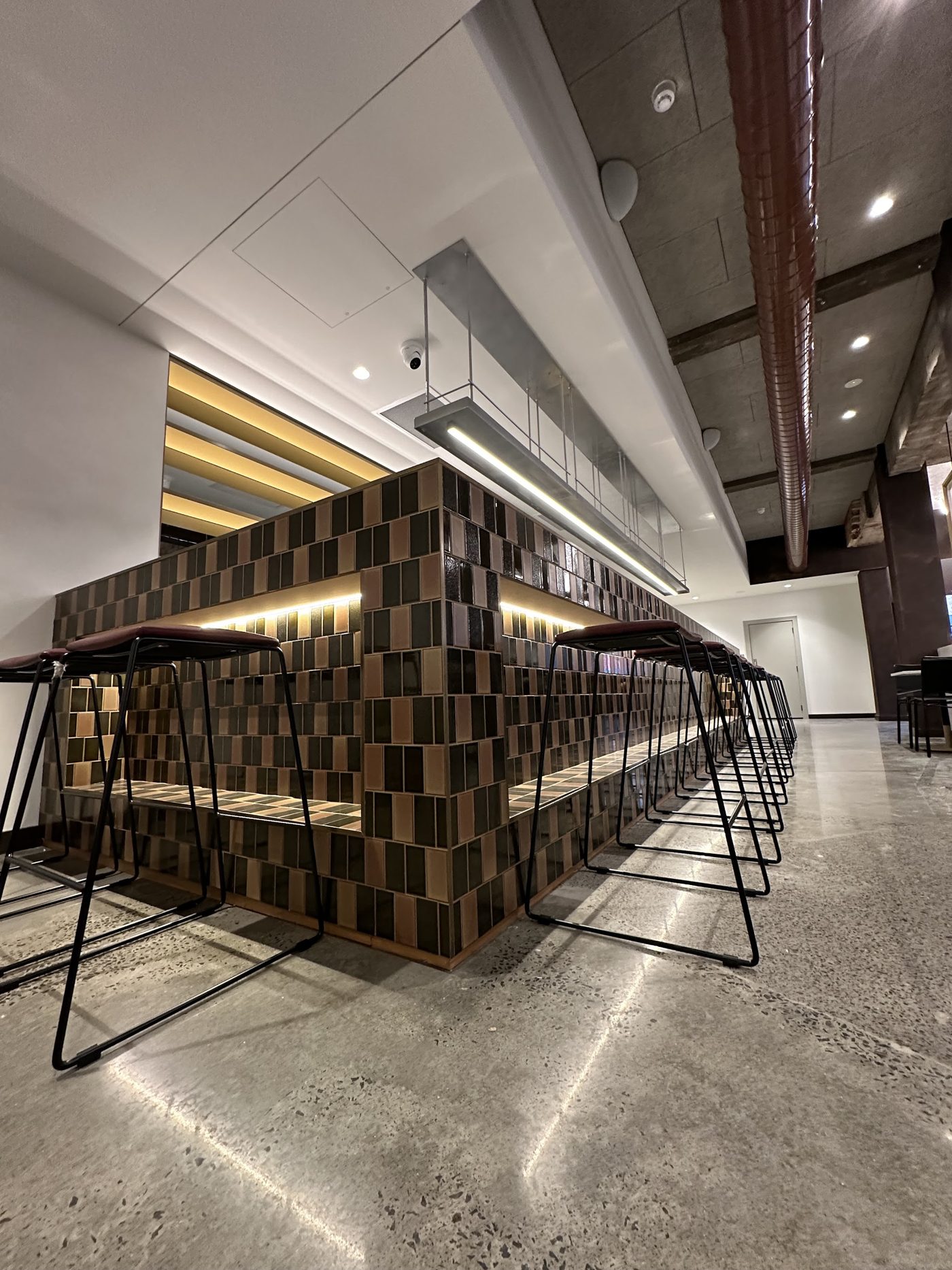Tiled bar with LED strip lighting under the counter lip and a pendant light above