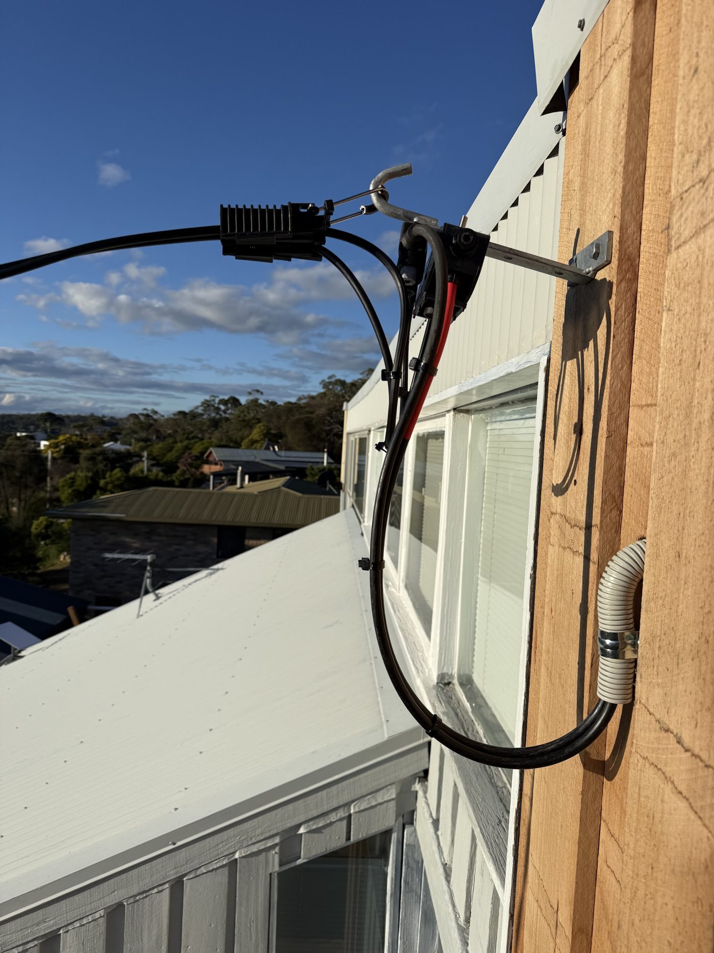 Service cable connection point fixed to the eave of a house